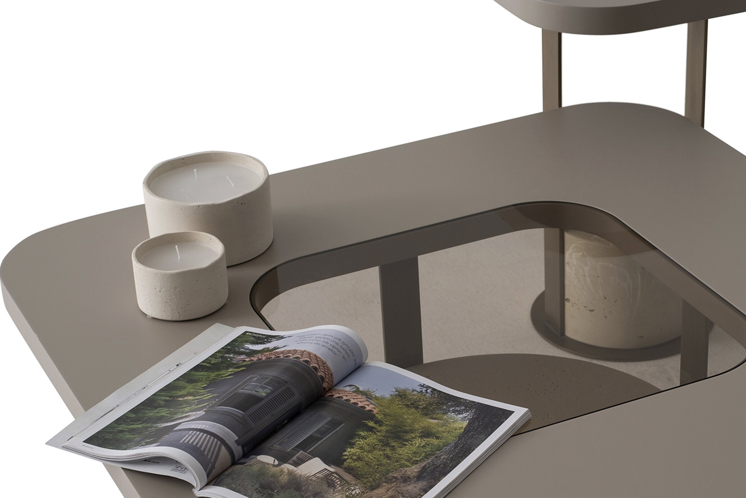 Sleek beige modern coffee table with a glass inset, decorated with white candles and an open magazines, perfect for contemporary living room decor.