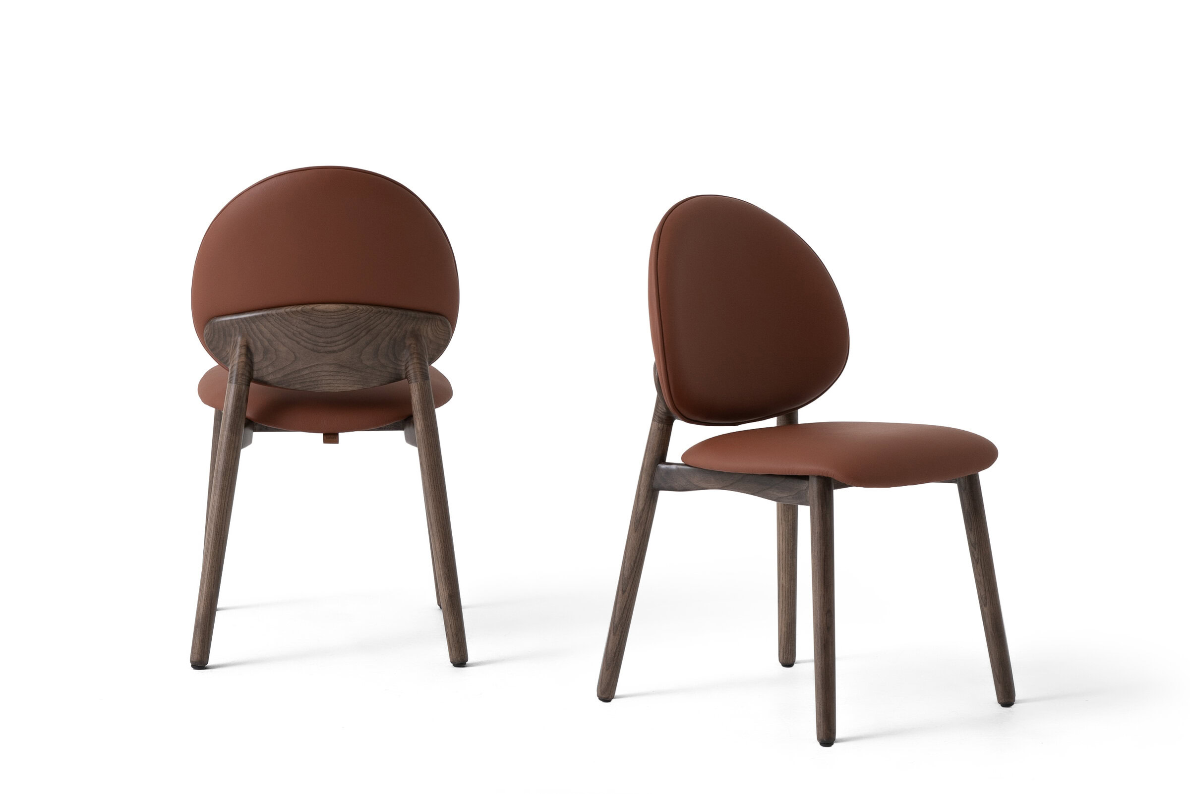 Elegant brown upholstered dining chairs with wooden legs, perfect for contemporary dining rooms and kitchens. Comfortable, stylish, and durable furniture from Saloni Furniture.