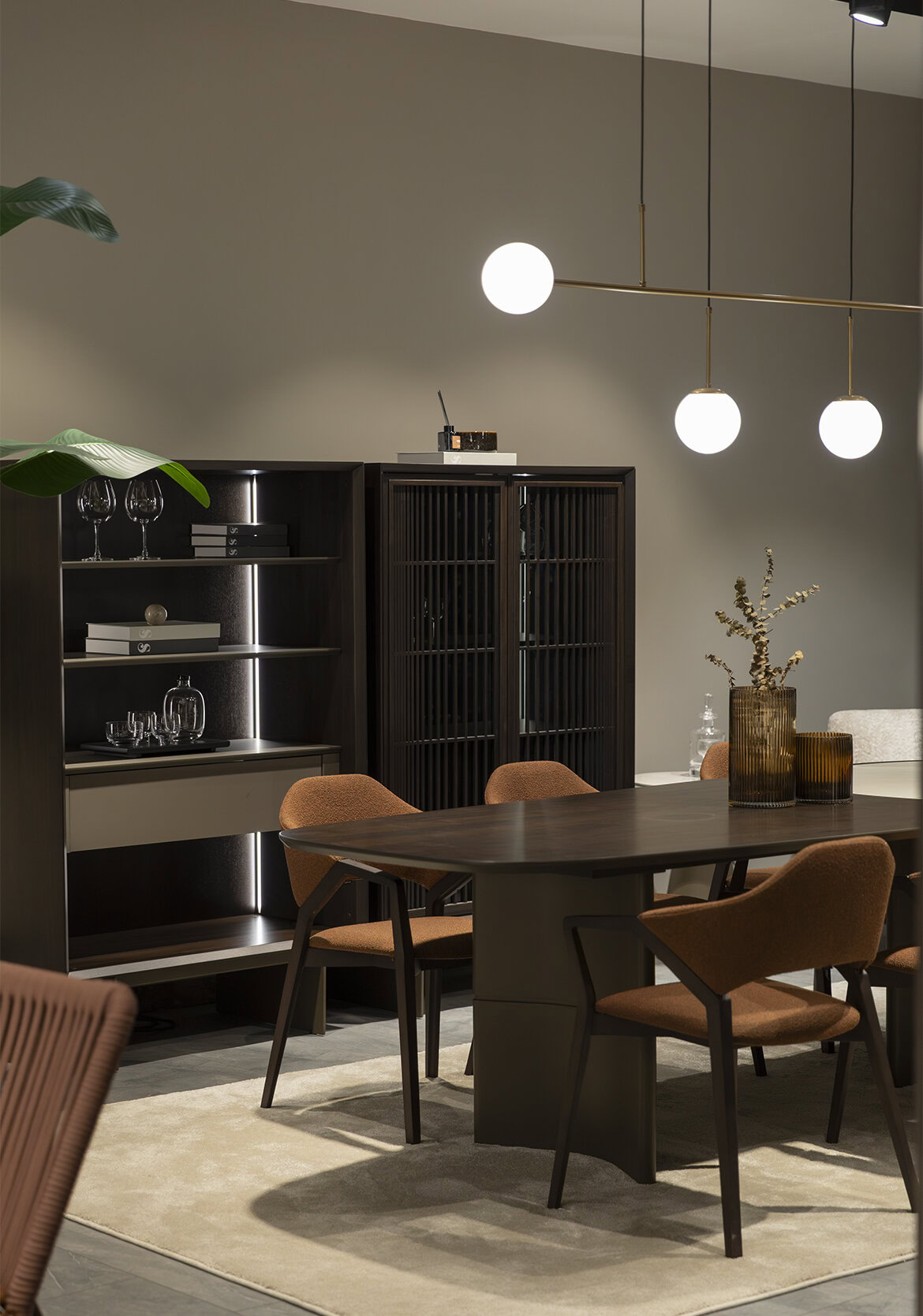 Sleek modern dining room featuring Saloni Furniture's elegant dark wood dining table, comfortable upholstered chairs, and stylish display cabinets, creating a contemporary and inviting space.