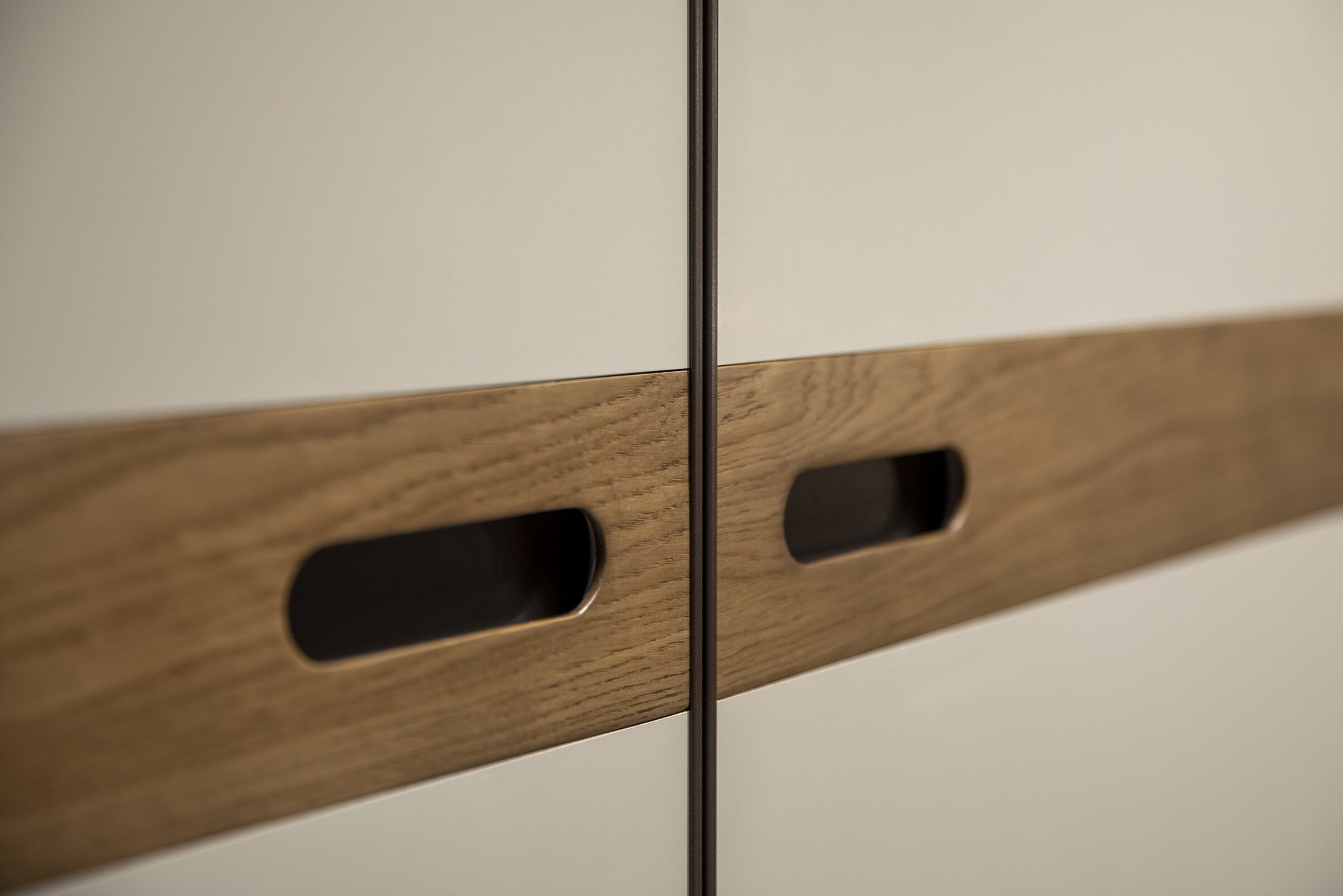 Contemporary wooden wardrobe with sleek recessed handles, blending modern and natural design elements for stylish and functional furniture.