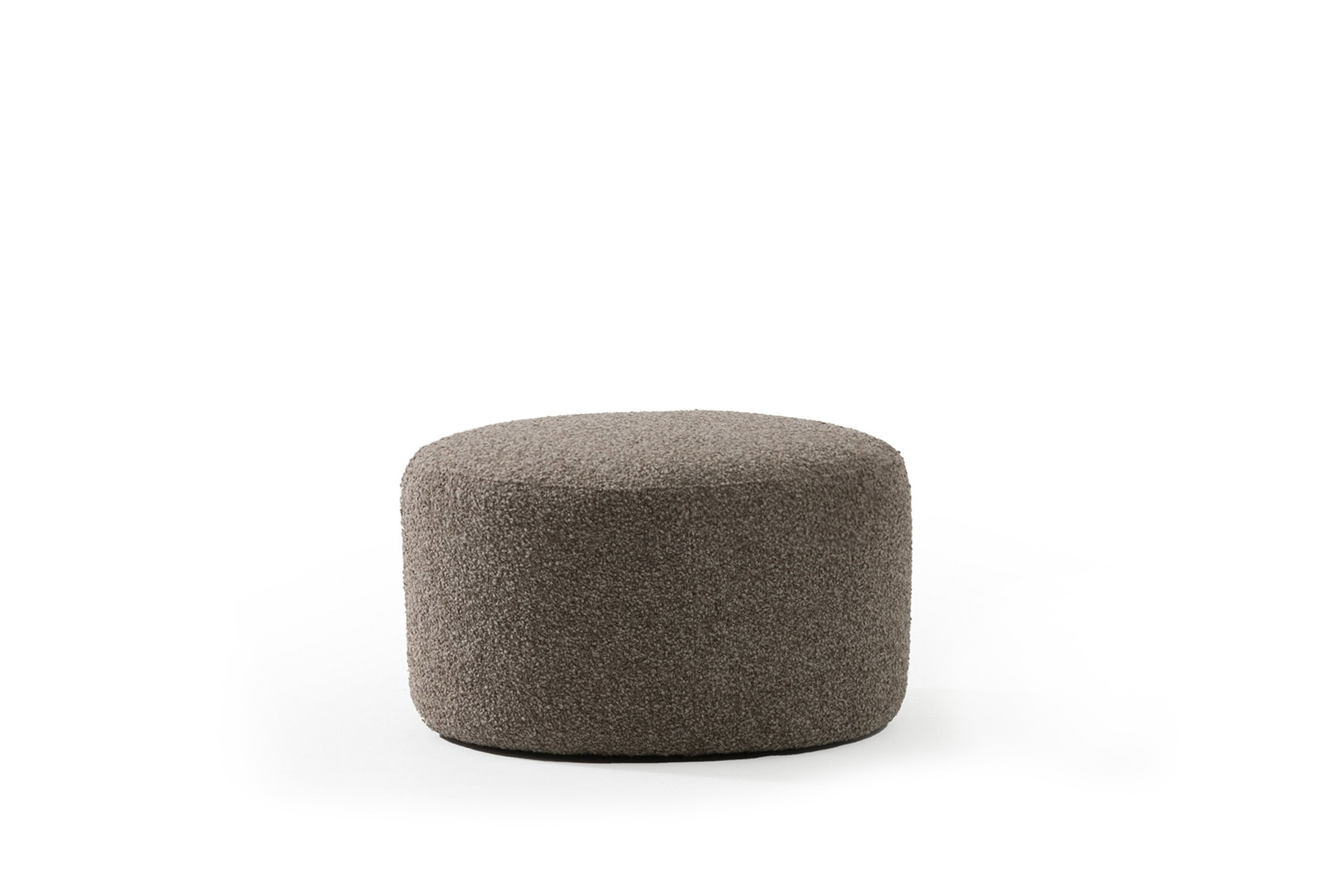 Soft textured round ottoman in neutral brown upholstery, perfect for modern living rooms and contemporary furniture decor.