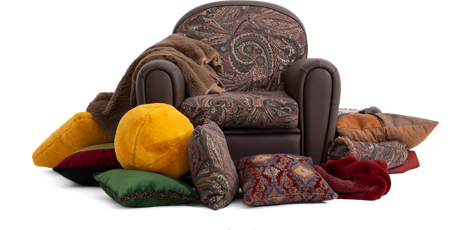 Comfortable upholstered armchair surrounded by colorful cushions and cozy throws, ideal for relaxing and adding style to your living space.
