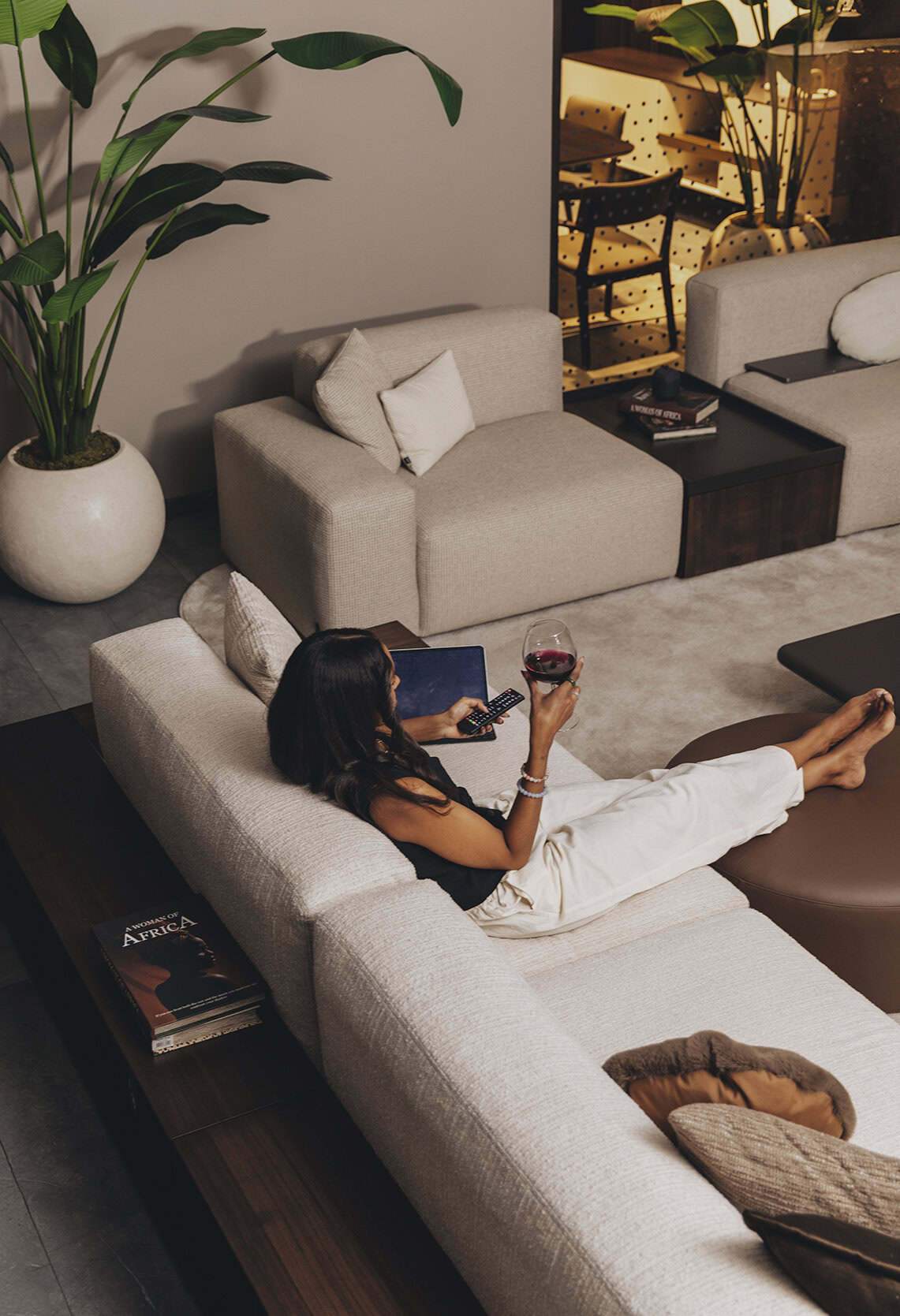 Contemporary beige fabric sofa with plush cushions, perfect for modern living rooms, accompanied by stylish side tables and decorative elements.