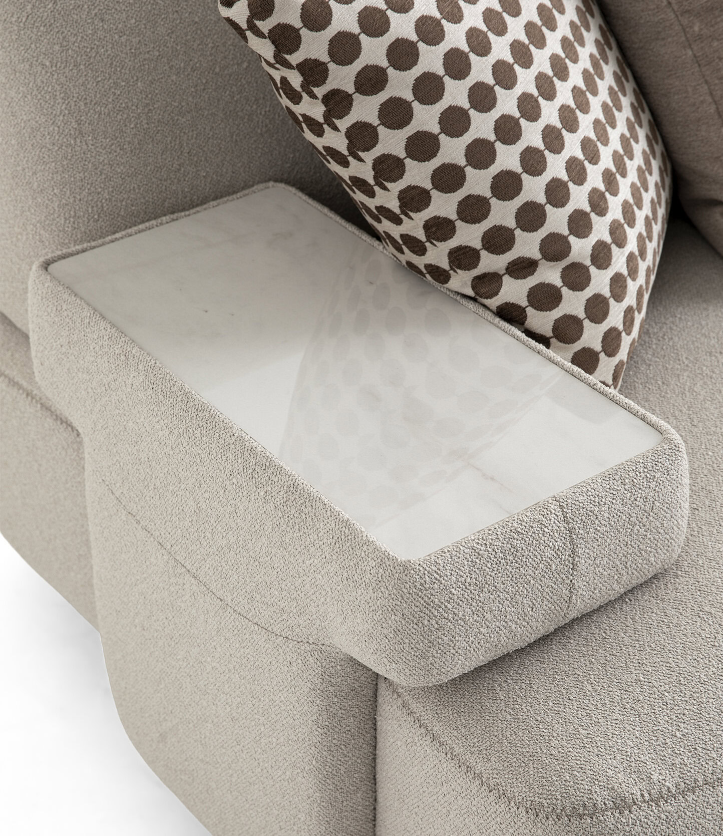Modern beige sofa with a built-in glass side table for convenience and style.