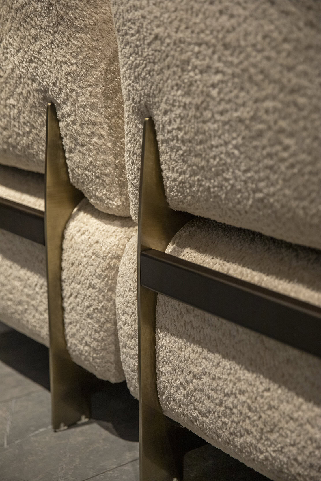 Luxurious beige textured velvet upholstered furniture with sleek brass and black metal accents, blending modern elegance with plush comfort in contemporary home decor.