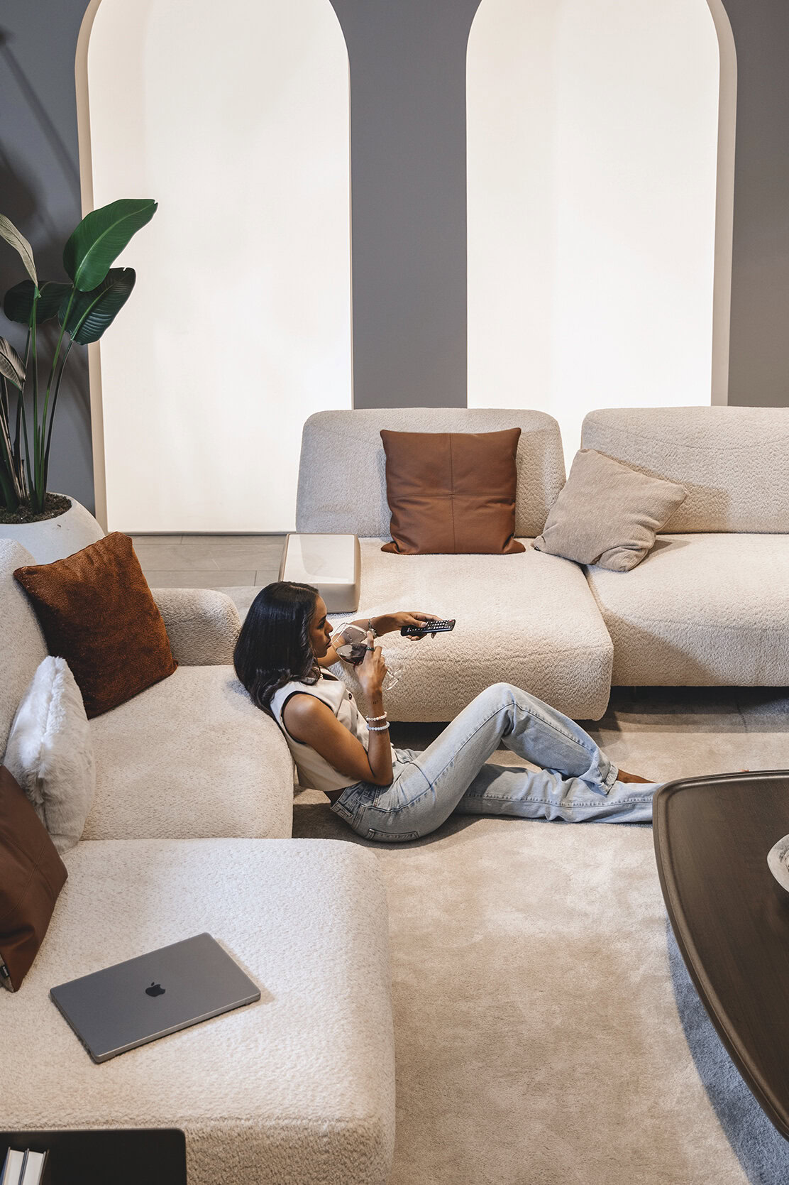 Stylish modern living room with plush beige sofas, accent pillows, and contemporary decor, featuring a cozy atmosphere perfect for relaxation and entertainment.