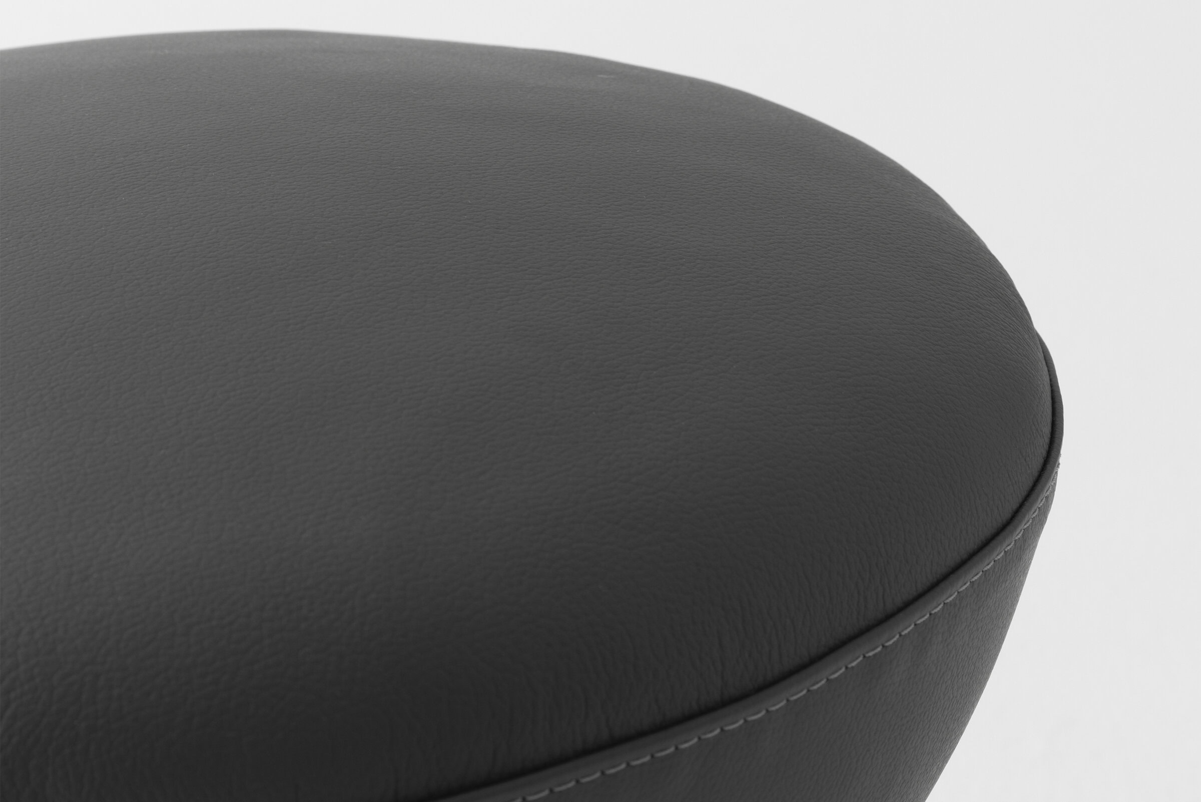 Soft black leather upholstered furniture with detailed stitching, modern design, and sleek rounded edges. Perfect for contemporary living spaces and designed to offer comfort and style.