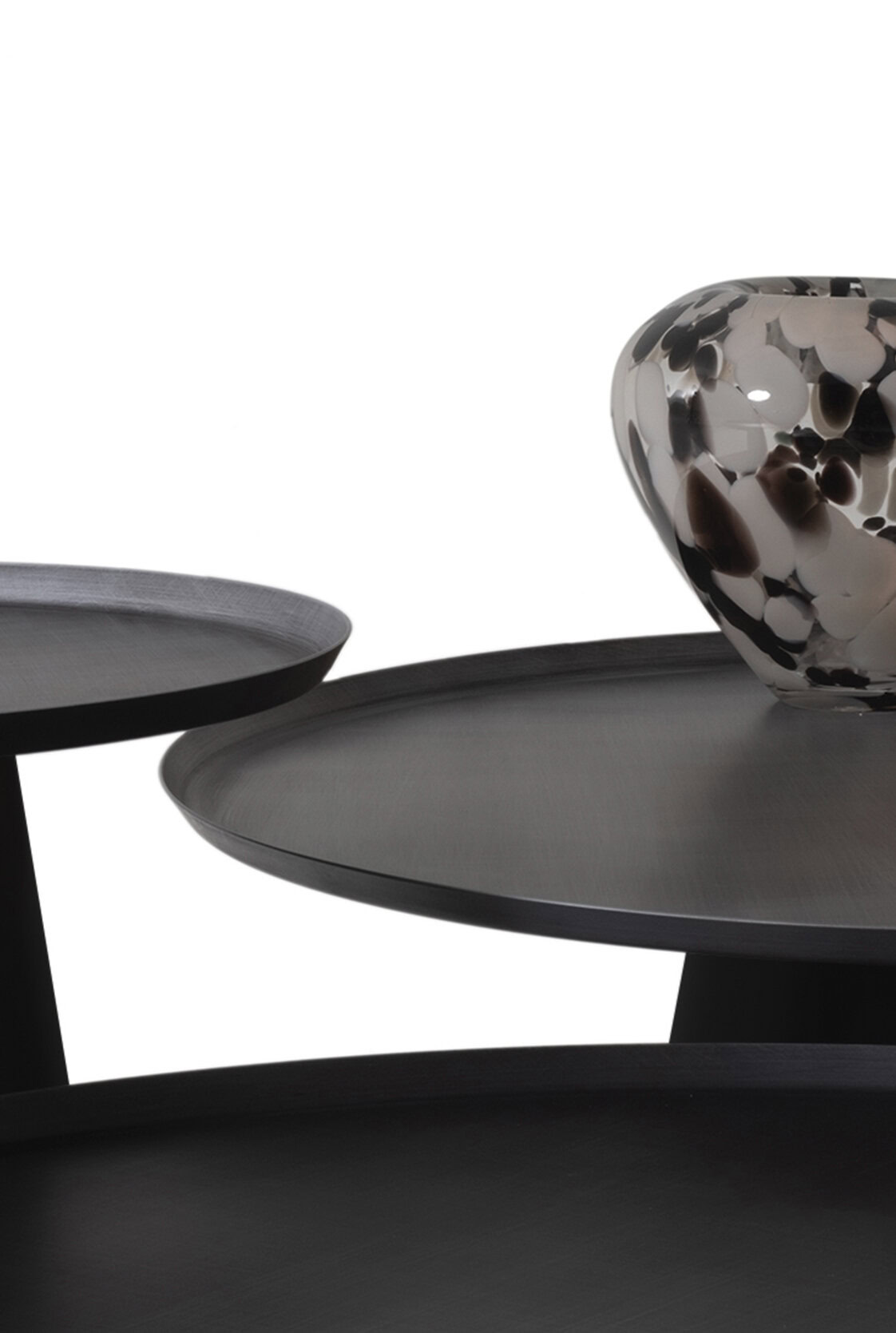 Contemporary black and gray accent tables with textured surfaces and decorative ceramic vases, perfect for modern living room decor.
