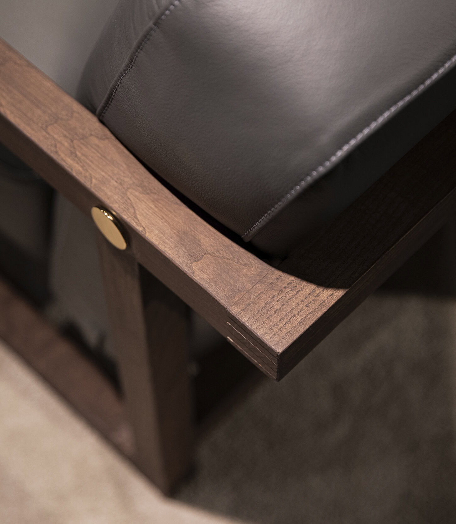 Smooth brown wooden corner of furniture with dark leather cushion for modern bedroom or living room decor.