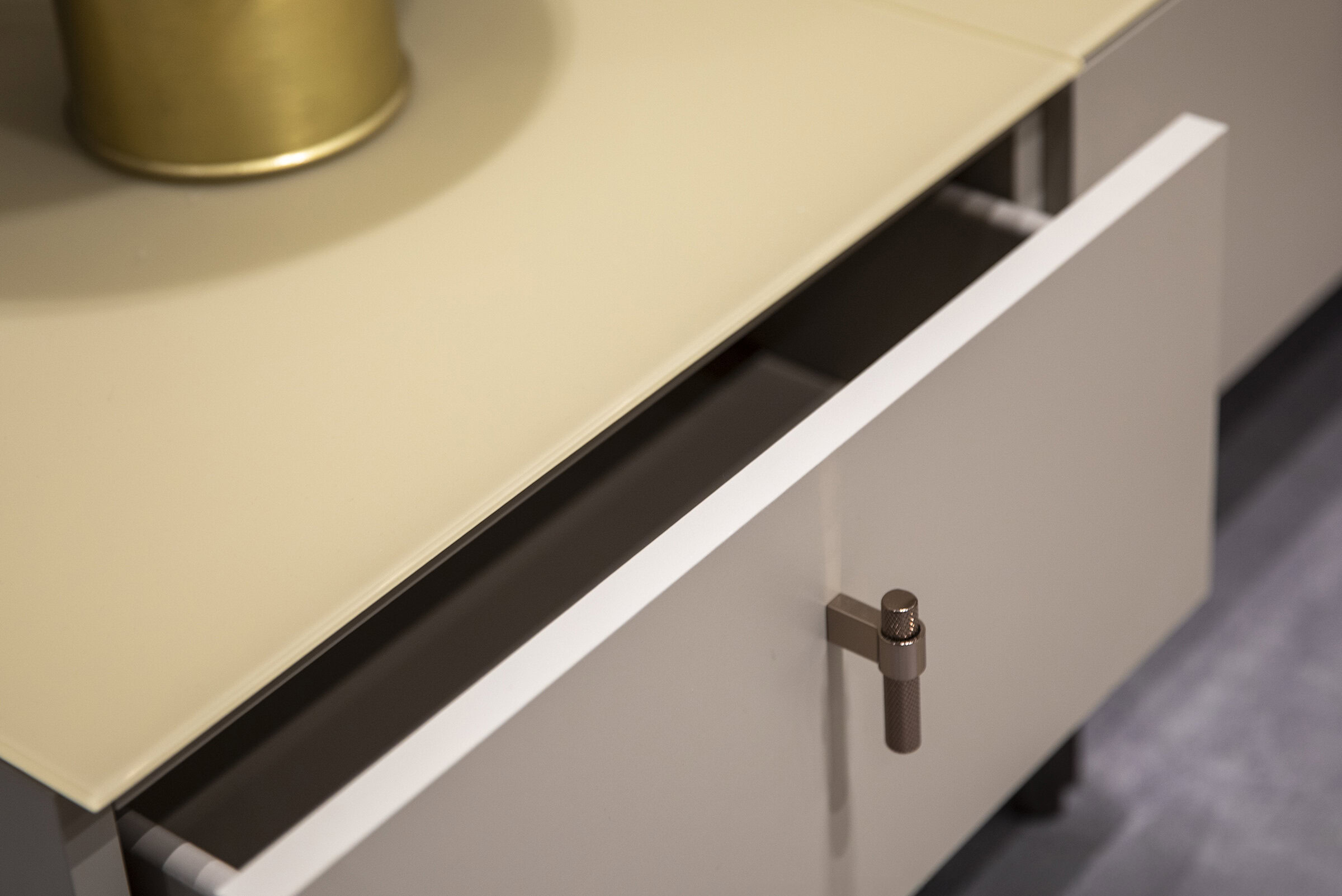 High-quality modern bedroom dresser or cabinet with a partially open drawer and metallic handle, showcasing sleek design and craftsmanship for stylish home storage solutions.