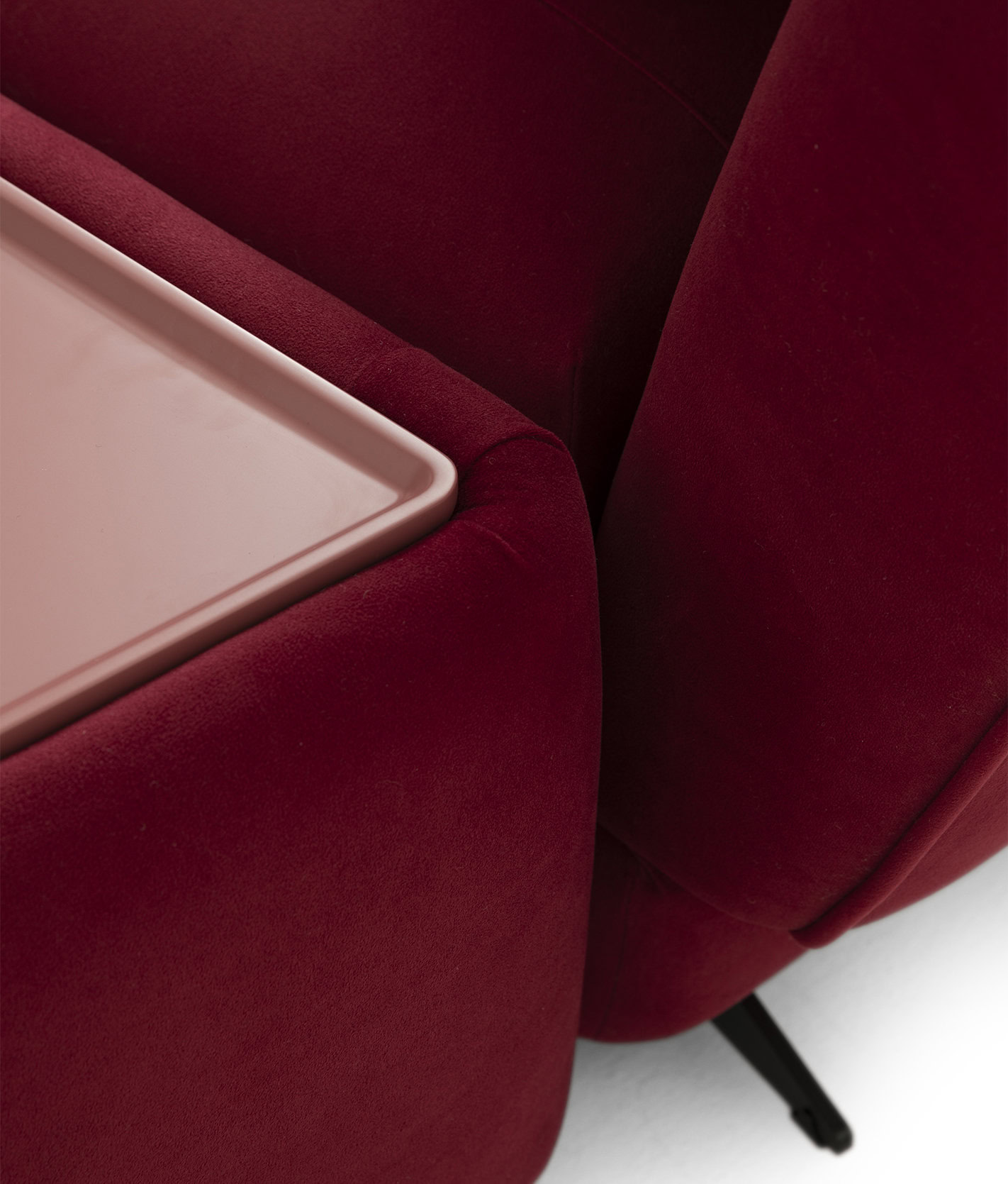Close-up of a luxurious red velvet sofa with a modern design, showcasing plush upholstery and sleek black legs, perfect for contemporary living rooms.