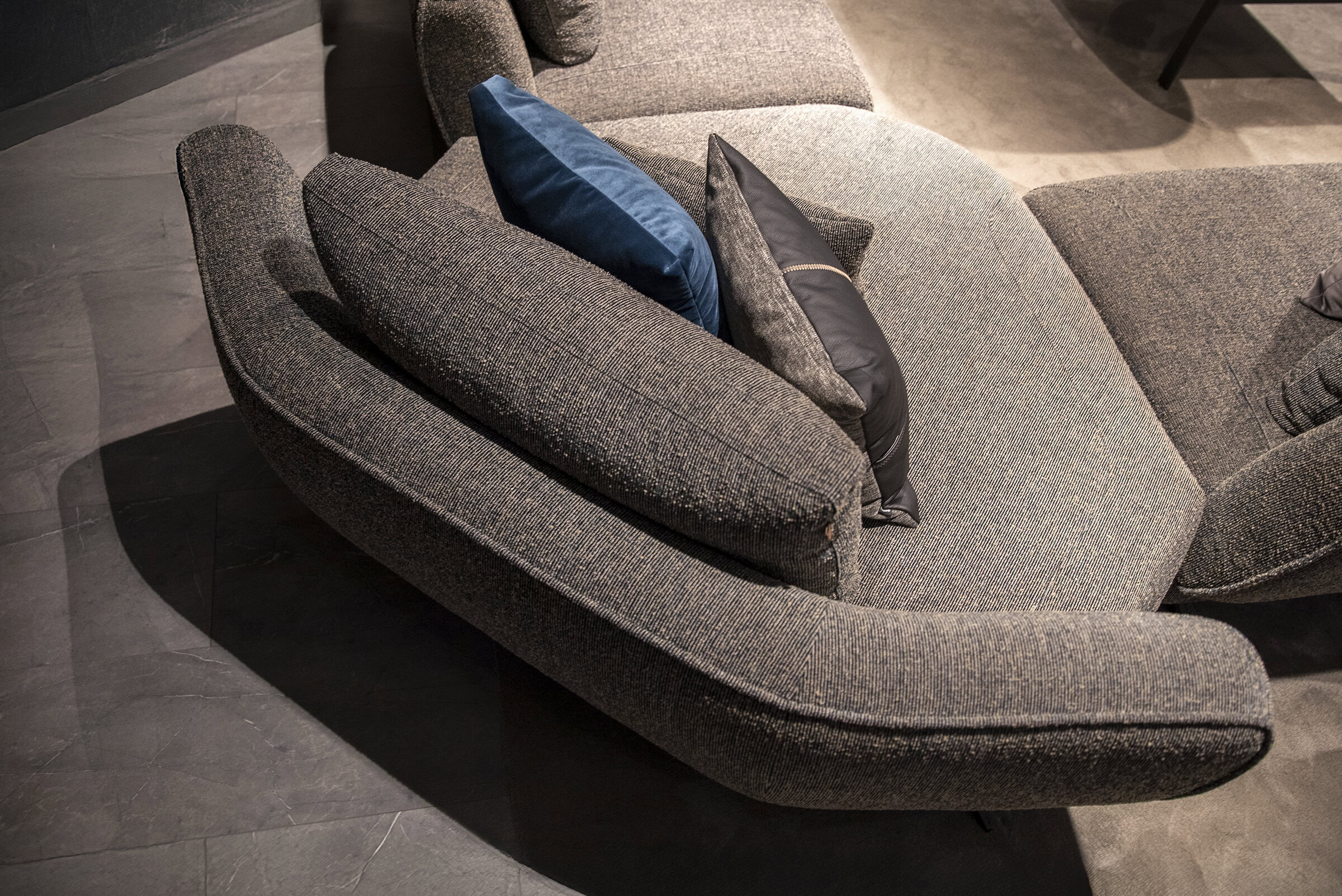 Contemporary gray fabric sofa with multiple decorative cushions, perfect for modern living room decor, showcasing high-quality craftsmanship and stylish design by Saloni Furniture.