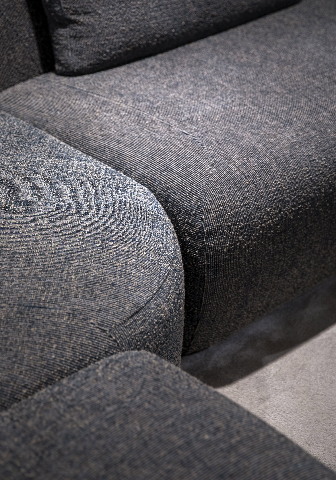 Soft textured fabric upholstery on modern gray sofa with detailed stitching and cushioning for stylish, comfortable living room furniture.