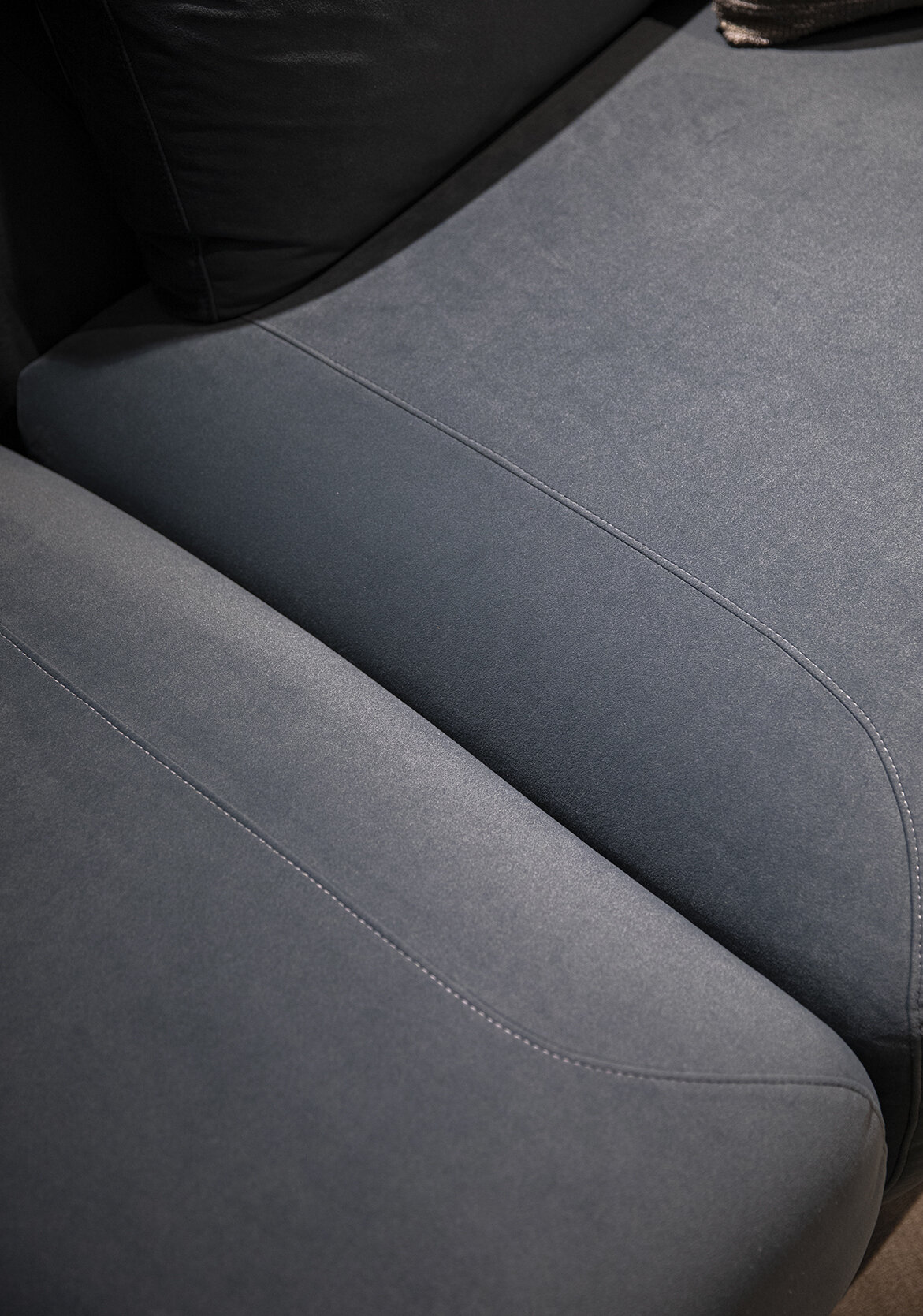 Luxurious dark gray fabric sofa with sleek stitching, modern design, and plush cushioning for stylish comfort in contemporary living spaces.