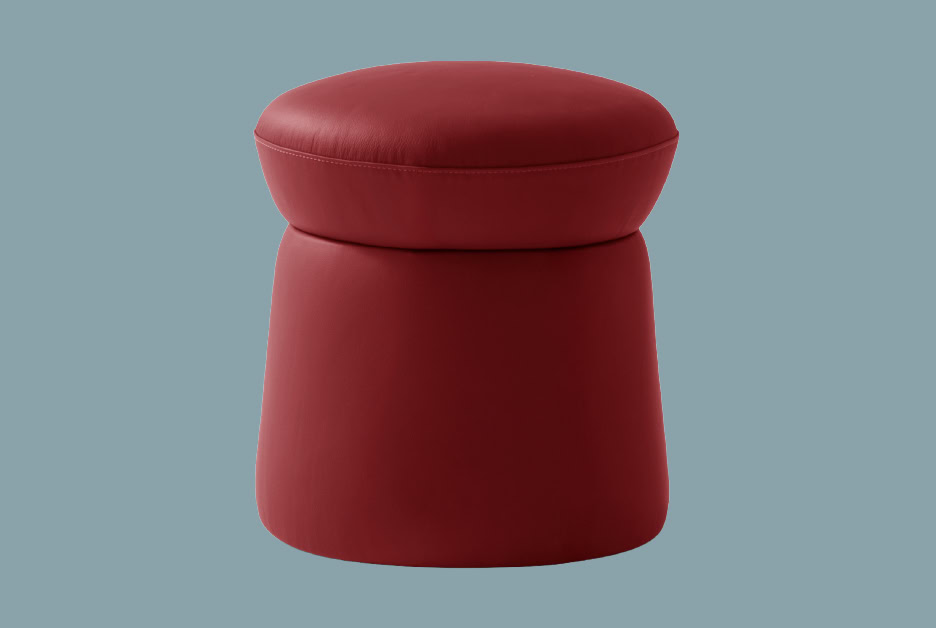 Red ottoman with a plush, cushioned top and cylindrical base, ideal for living room seating or as a stylish footrest. Crafted with high-quality upholstery, blending comfort and contemporary design.
