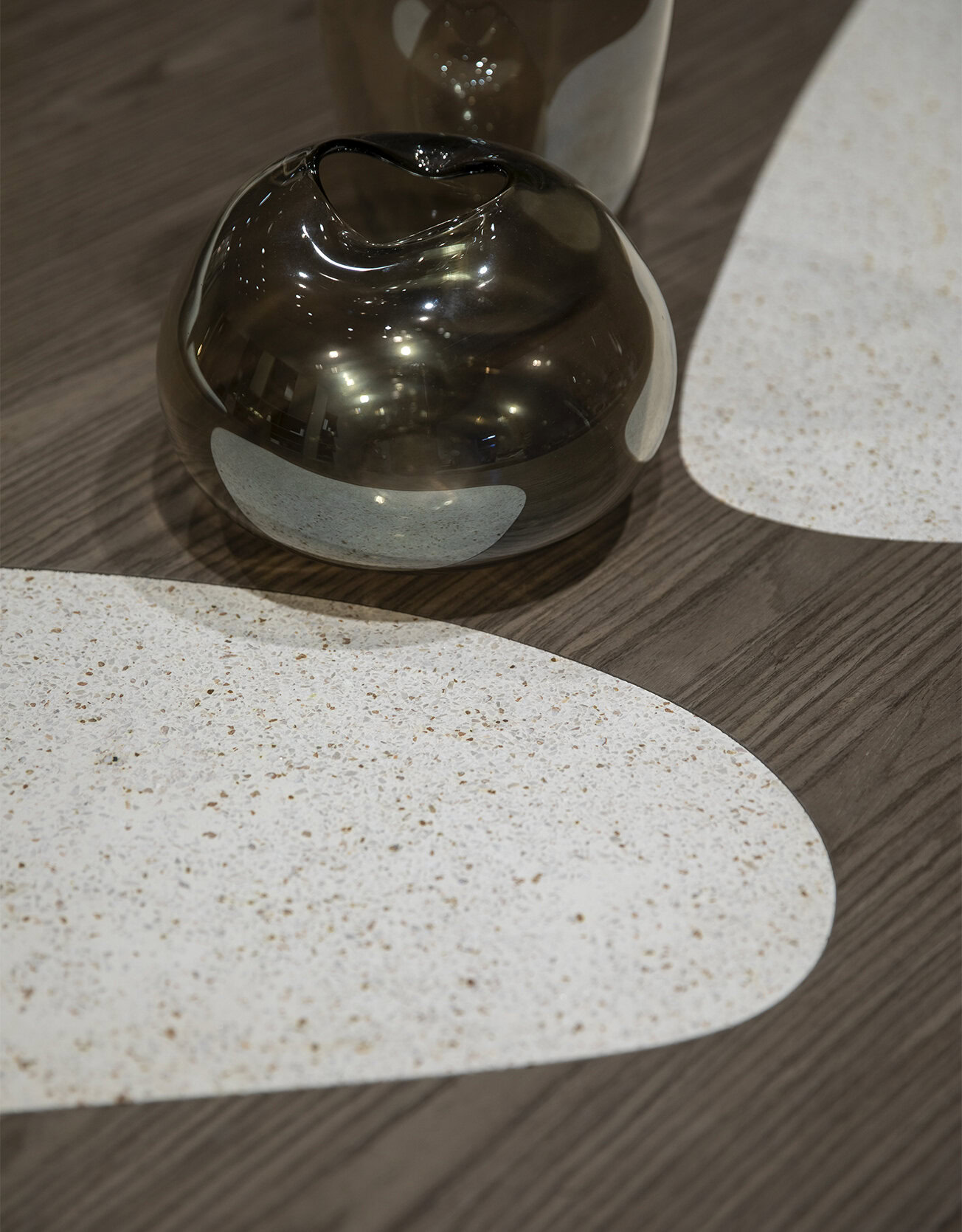 Shiny metallic vase on wooden table with terrazzo design placemats, modern home decor, stylish table centerpiece, Saloni Furniture.