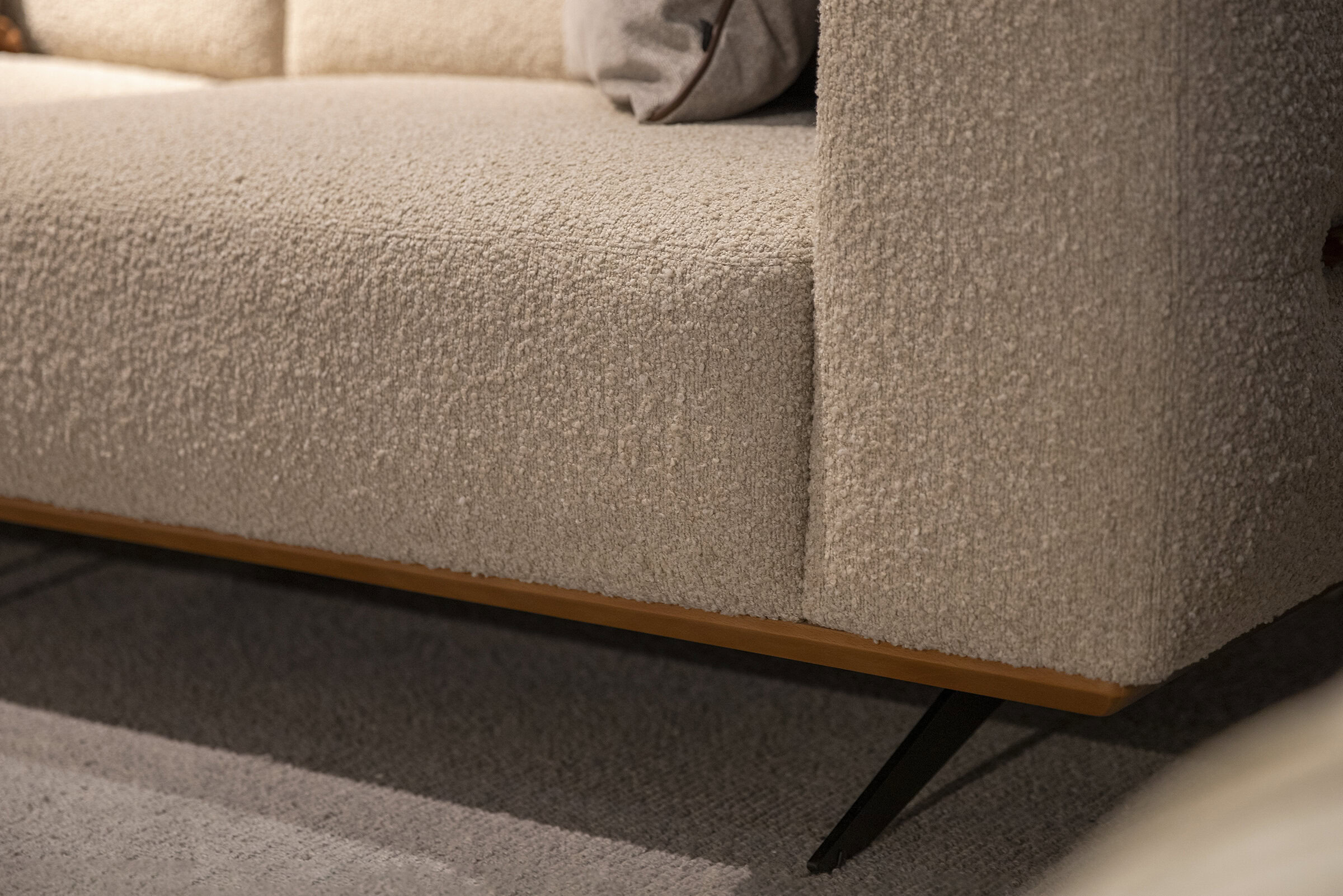 Soft beige upholstered sofa with modern wooden and metal legs, luxurious fabric, perfect for stylish, comfortable living rooms.