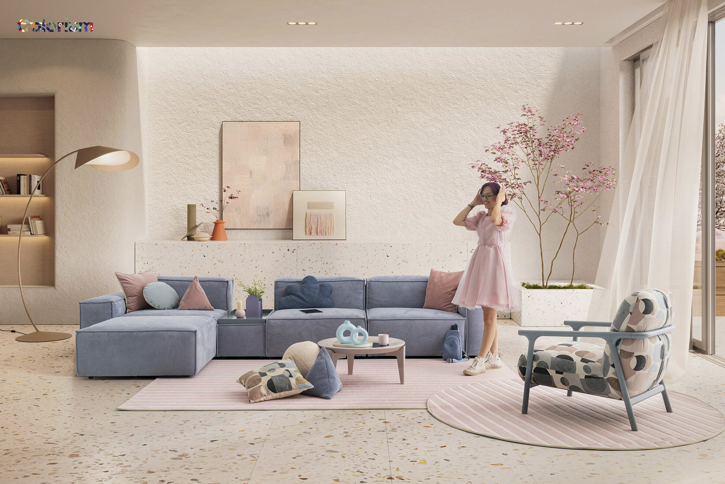 An elegant living room featuring a pastel blue sectional sofa, pink cushions, and a cozy pink area rug. A woman in a pink dress stands near a large window with sheer curtains, surrounded by stylish de.