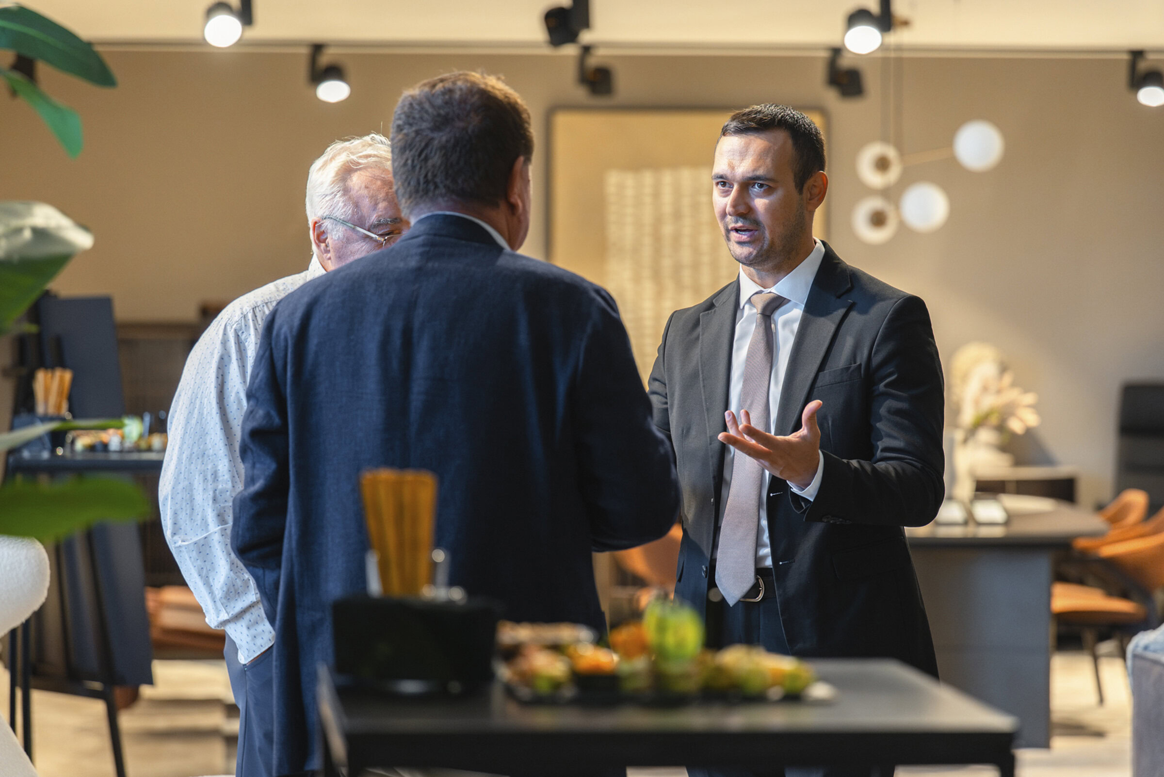 Modern business professionals having a discussion in a stylish office setting with contemporary furniture.