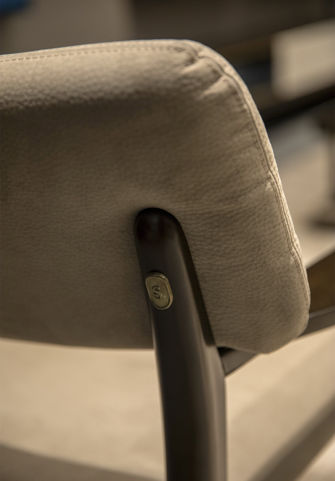 Modern beige upholstered office chair with black metal frame and adjustable tilt mechanism, perfect for contemporary workspace comfort and style.
