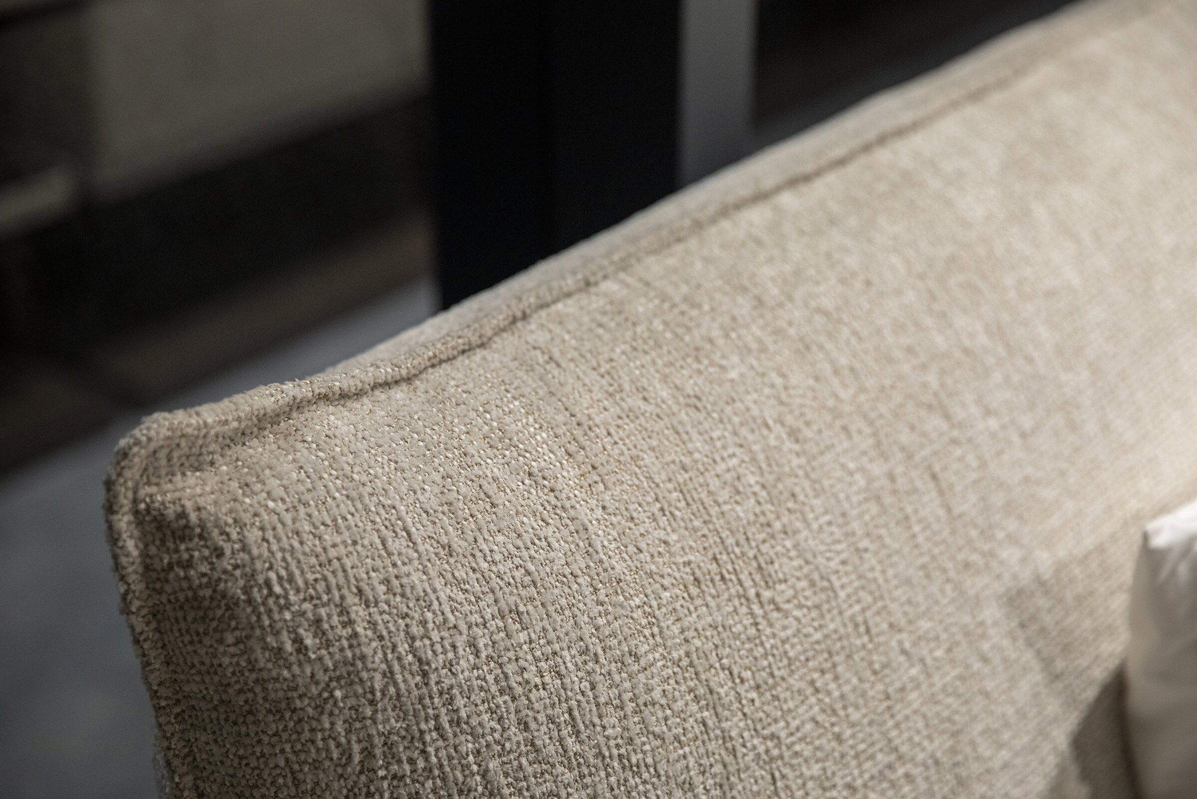 Luxurious beige textured fabric upholstery on a modern sofa for elegant living room decor and comfortable seating.